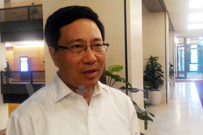 Deputy PM and Foreign Minister Pham Binh Minh talks to reporters on the sidelines of the 14th parliament's first session (Photo: VNA)”