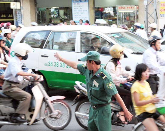 An activist attends in traffic regulation to reduce traffic jam during peak hours in HCMC (Photo: SGGP)
