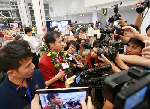 Hundred fans and media welcome Olympics Gold winner in Noi Bai International Airport. (Photo:SGGP)