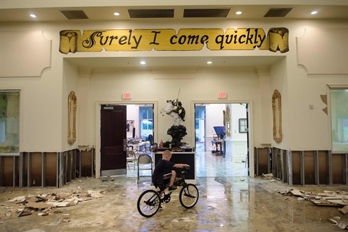 A boy rides his bike inside the flood damaged Life Tabernacle Church on August 15, 2016 in Baton Rouge, Louisiana. Floods ravaged the US state of Louisiana, leaving six people dead and thousands more forced to flee rising waters after days of catastrophic rainstorms. AFP/VNA Photo