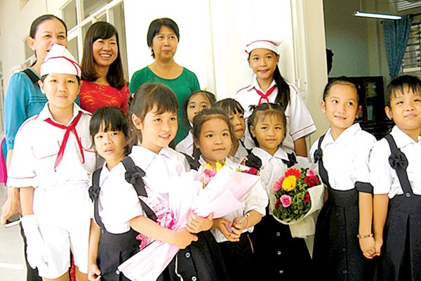 Teacher and students in Le Dinh Chinh Primary School in Binh Thanh District welcome the new academic year (Photo: SGGP)