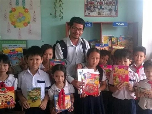 Nguyễn Quang Thạch poses with children holding books received through the Books for rural areas of Vietnam programme. The programme has recently been awarded the 2016 UNESCO King Sejong Literacy Prize. Photo vietnamplus.vn