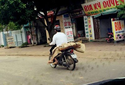 Lo Van Muon carries the body of his dead sister on his motorbike in a heartbreaking photo posted in internet