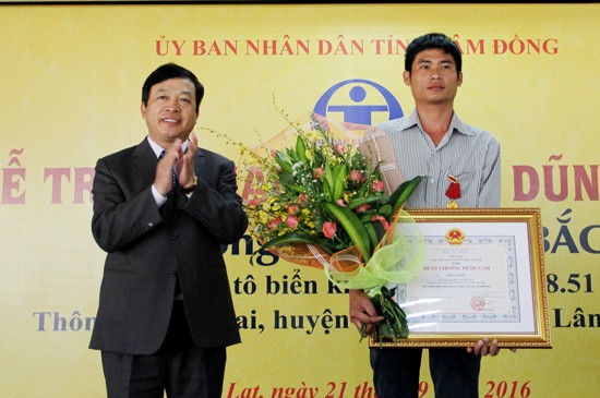 The People’s Committee in Lam Dong Province Doan Van Viet awards the Merit of Bravery to truck driver Phan Van Bac (R). (Photo: Sggp)