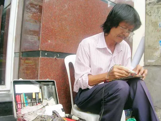 Người thợ khắc chữ bên góc phố đông người