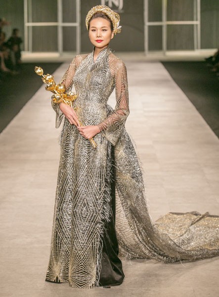 Top model Thanh Hang wears a set of Vietnamese traditional ao dai, a golden head turban worth VND500 million (US$22,400), and a bunch of lotus flowers made of gold worth VND2.1 billion (US$94,000).