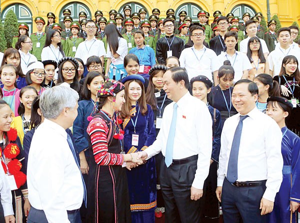 President Quang shakes hand an ethnic minority student at the meeting (Photo: SGGP)