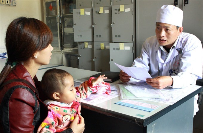 A medical worker helps people affected with HIV/AIDS in Mộc Châu District in the northern mountain province of Sơn La. The rate of mother-to-child transmission of HIV in the country fell by 16 per cent between 2009 and 2015. Photo VNA/VNS Dương Ngọc