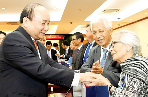 Prime Minister Nguyen Xuan Phuc (L) shakes hands with Vietnamese French Professor Tran Thanh Van and his wife at the overseas Vietnamese conference in downtown HCMC on November 12 (Photo: SGGP)
