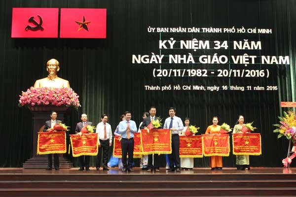 Chairman of the People's Committee of HCM City Nguyen Thanh Phong Offers certificates of merit and medals to individuals who have outstanding contribution to the city’s education and training sector. (Photo: Sggp)