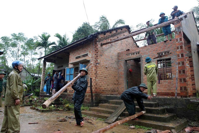 Army and police officers help local residents fix houses in An My Commune, Hoai An District in Binh Dinh Province after damage caused by recent flooding. (Photo: VNA/VNS)