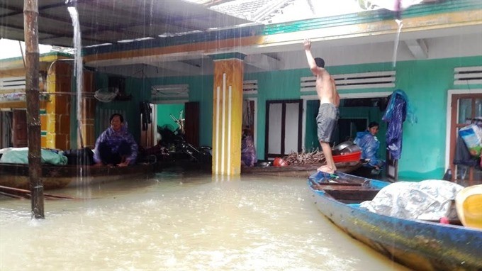 Residents of Quang Nam Province collect property from a flooded home. — Photo Quang Nam Portal -VNS