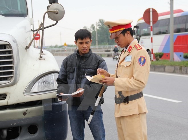 Transport policeman checks driving licence of a bus driver on Highway 10, in the northern province of Thái Bình. — VNA Photo