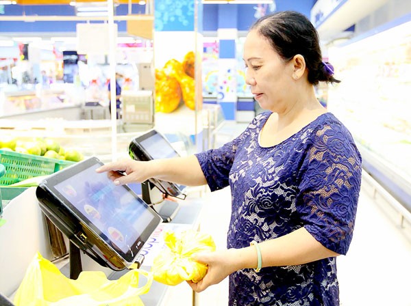 A consumer checks the origin of a pork piece at a machine installed in Co.opmart Foodcosa, Go Vap district, HCMC (Photo: SGGP)