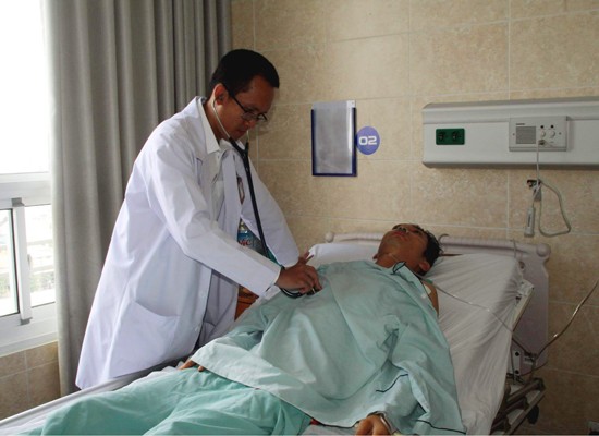A medical is examining a patient after the surgery (Photo: SGGP)