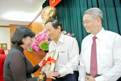 Head of the Department of Propaganda and Training of the HCMC Party Committee Than Thi Thu offers books to the editorial board. (Photo: Sggp)