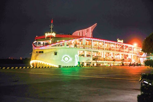 Tourists have dinner at floating restaurant on Sai Gon River