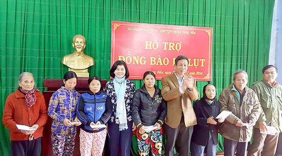 Ms. Ly Viet Trung, deputy editor-in-chief of Saigon Giai Phong Newspaper presents gifts for poor familiers.