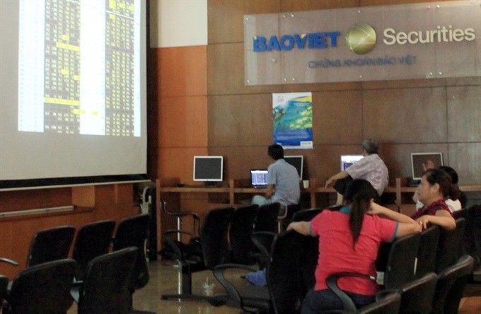 Investors follow movements of share prices at Bao Viet Securities Company in Hanoi. — VNA/VNS Photo Tran Viet