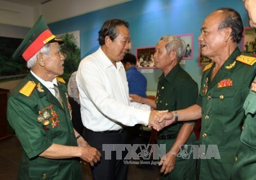 Deputy PM Truong Hoa Binh (in white) shakes hand with a veteran revolutionist. (Source: VNA)