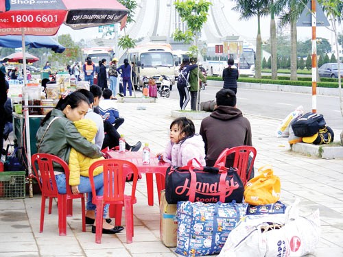 People awaiting coaches in front of a supermarket in the north central province of Thanh Hoa on February 1 (Photo: SGGP)