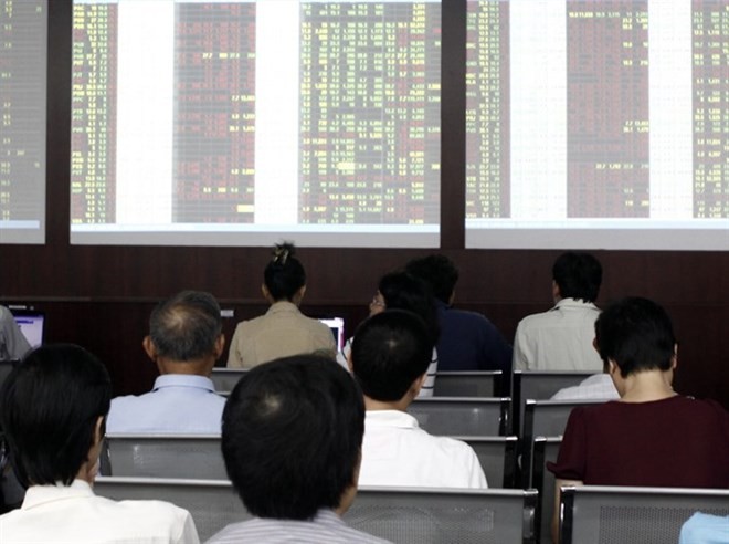 Investors at Sacombank Securities Company in HCM City. The stock market ended mixed yesterday with the benchmark VN Index falling from the nine-year high of 703.18 points (Photo: VNA)