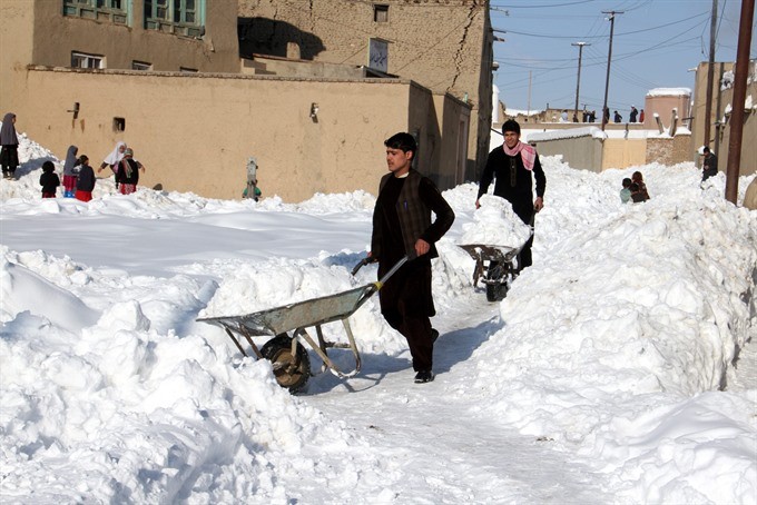 People remove snow from their house in Ghazni, Afghanistan