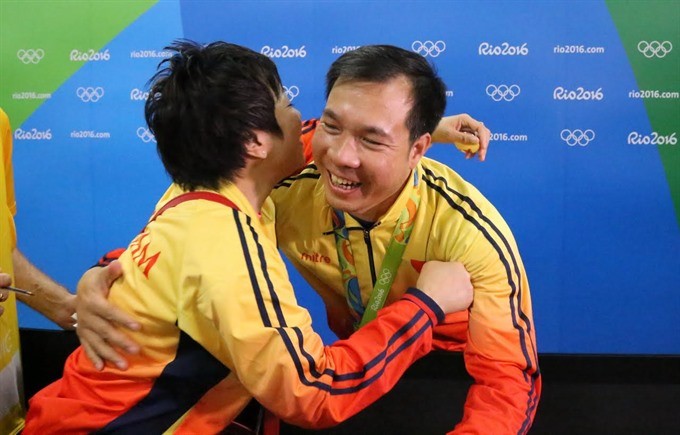 Hoang Xuan Vinh (right) and his coach Nguyen Thi Nhung celebrate with each other after Vinh wins his Olympic gold medal at the Rio Games last August. — Photo congly.vn
