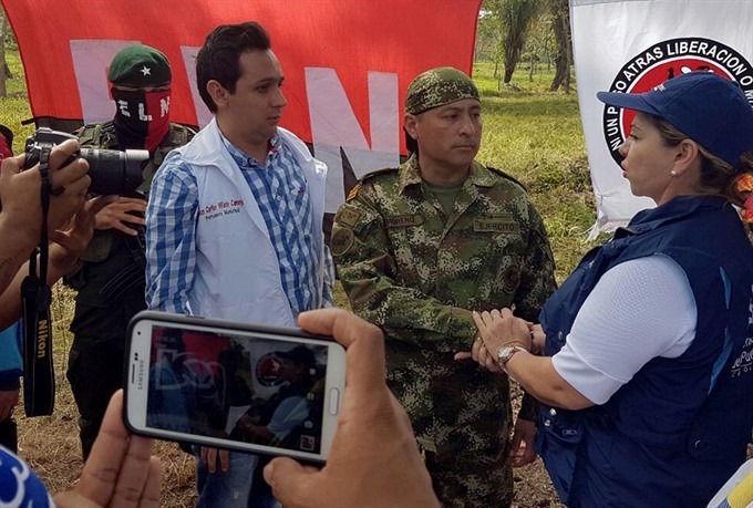 A handout photo made available by the Colombian Ombudsman General Office showing the National Liberation Army (ELN) releasing Colombian soldier Fredy Moreno Mahecha (2-R) in Arauca, Colombia, close to the border with Venezuela, on Monday. Moreno Mahecha was kidnapped on 24 January and was released a day before the beginning of peace talks between the government and ELN, in Ecuador. — EPA/VNA Photo