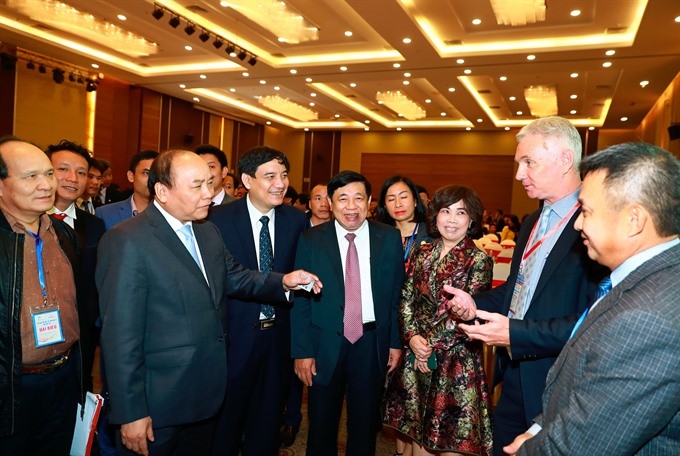 Prime Minister Nguyen Xuan Phuc (second left) speaks with foreign investors in Vinh City, Nghe An Province (Photo: VNA/VNS)