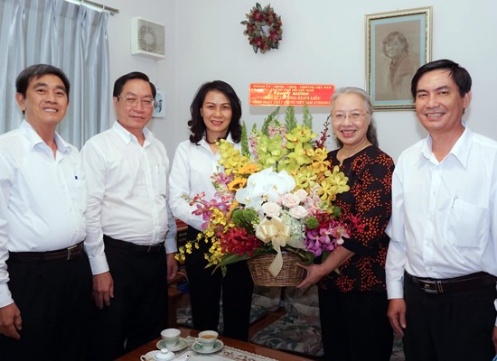 Dr. Truong Xuan Lieu ( 2nd, R) receives a bunch of flower from Ms. Thu (Photo: SGGP)