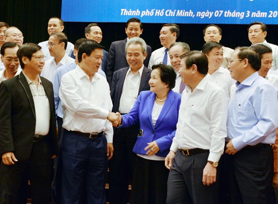 HCMC party chief Dinh La Thang shaking hands with a businesswoman at the conference (Photo: SGGP)