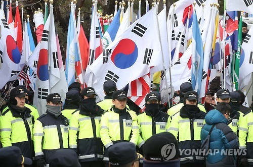 Activists urging the reinstatement of President Park Geun-hye rally behind police outside the Constitutional Court in Seoul on March 8, 2017. (Yonhap)
