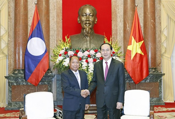 State President of Vietnam Tran Dai Quang (R) welcomes Lao Minister of Public Security Somkeo Silavong