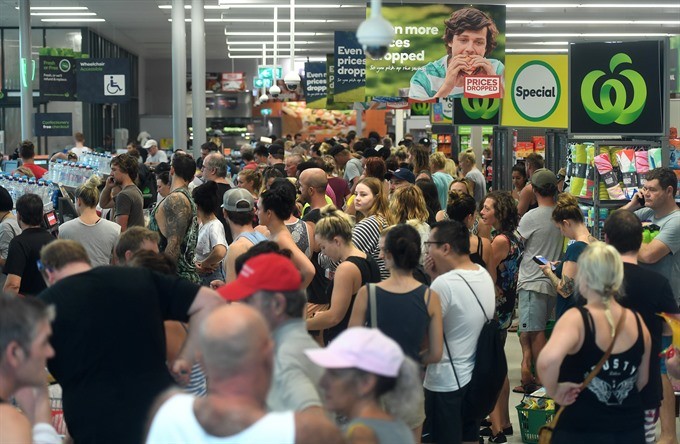 Locals queue at a supermarket seeking to replenish supplies after the store opens for the first time since Cyclone Debbie swept through Airlie Beach, Queensland, Australia, on Thursday. Cyclone Debbie has hit Queensland’s far north coast on Tuesday, as a category 4 cyclone, causing wide spread damage, torrential rain and power cuts. — EPA/VNA Photo