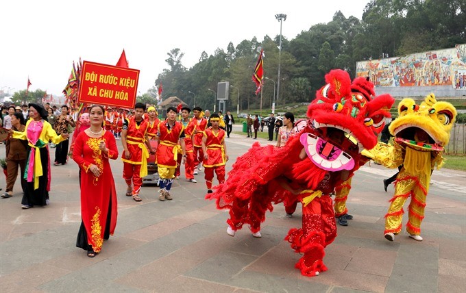 Dragon steps: The palanquin team from Chu Hoa Commune at the foot of the Nghia Linh Mountain is accompanied by a dragon dance team. (Photo: VNS)