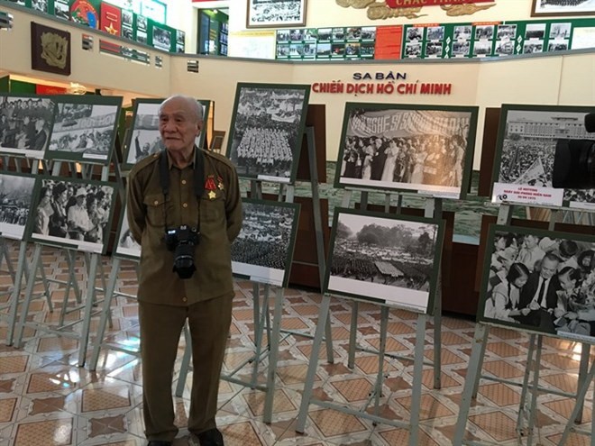 National treasure: Photojournalist Minh Loc with his photos at the Historical Moments exhibition (Source: VNA)