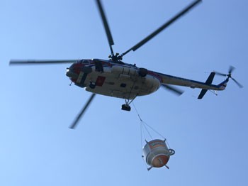 A helicopter carries the giant coffee mug to the opening ceremony. (Photo:SGGP)