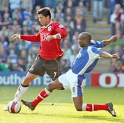 Hậu vệ Portsmouth Lauren (phải) cản phá mũi nhọn M.U. Cristiano Ronaldo