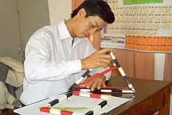Thầy Quy sáng chế đồ dùng dạy học dành cho học sinh khiếm thị. Ảnh: NGUYÊN KHÔI