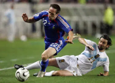 Tiền vệ Franck Ribery (trái, Pháp) té ngã trước sự truy cản của tiền vệ Paul Hartley (Scotland).
