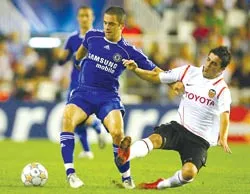 Pha tranh bóng giữa Joe Cole (trái) và David Villa trong trận đấu đêm thứ Tư.