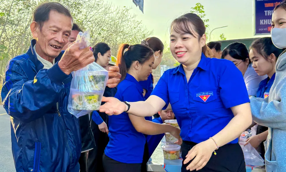 Bà con rất vui khi nhận đồ ăn sáng trước khi vào khám bệnh