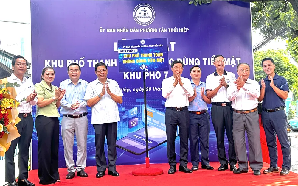 Lãnh đạo phường phường Tân Thới Hiệp cùng các đại biểu thực hiện nghi thức ra mắt "Khu phố thanh toán không dùng tiền mặt". ẢNH: THANH DUNG 