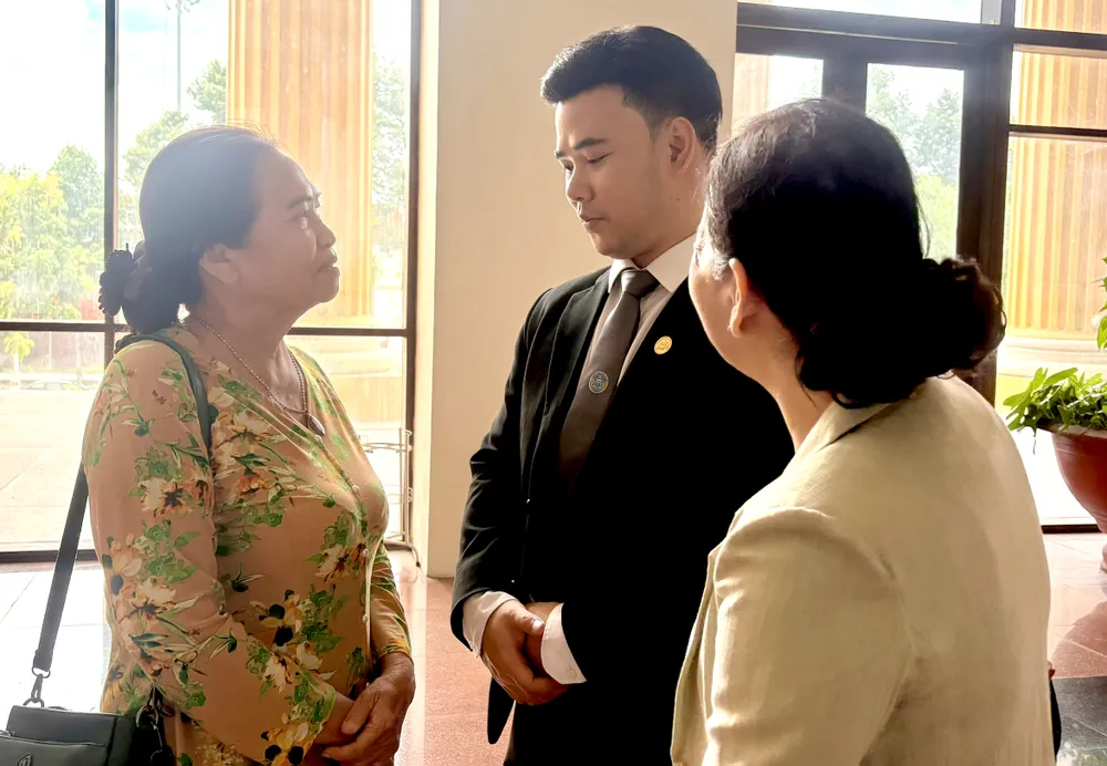 Mẹ của cố diễn viên Đức Tiến (bìa trái) trao đổi với luật sư sau phiên tòa. Ảnh: SONG MAI