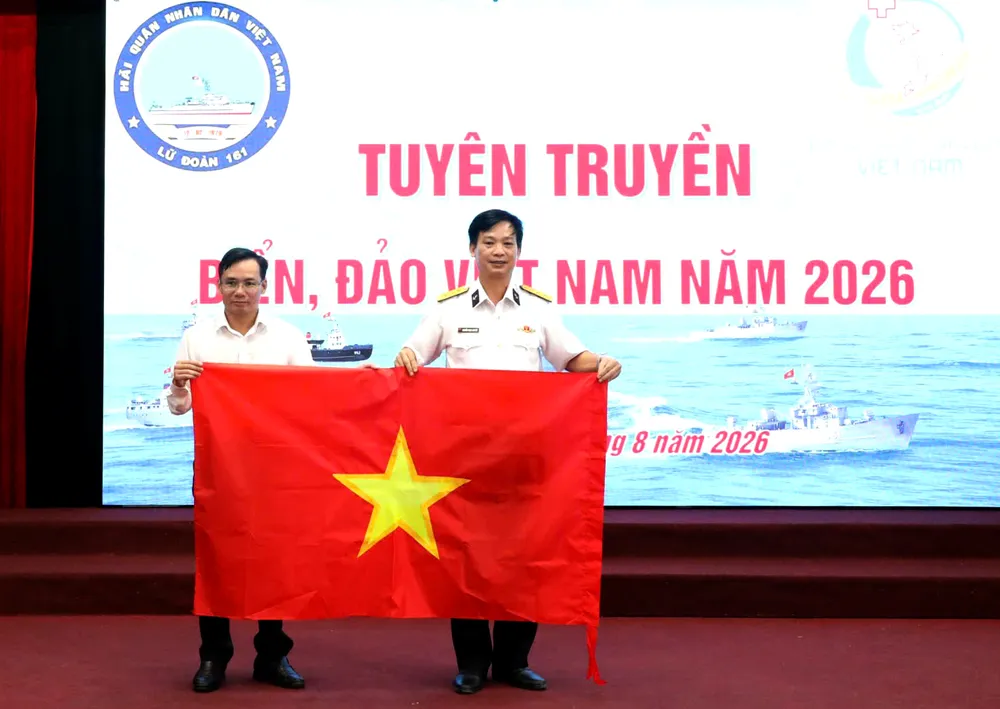 Tại chương trình, Trường Cao đẳng Công nghệ Y - Dược Việt Nam trao tặng Lữ đoàn 161 Hải quân 100 là cờ Tổ quốc. Ảnh: XUÂN QUỲNH