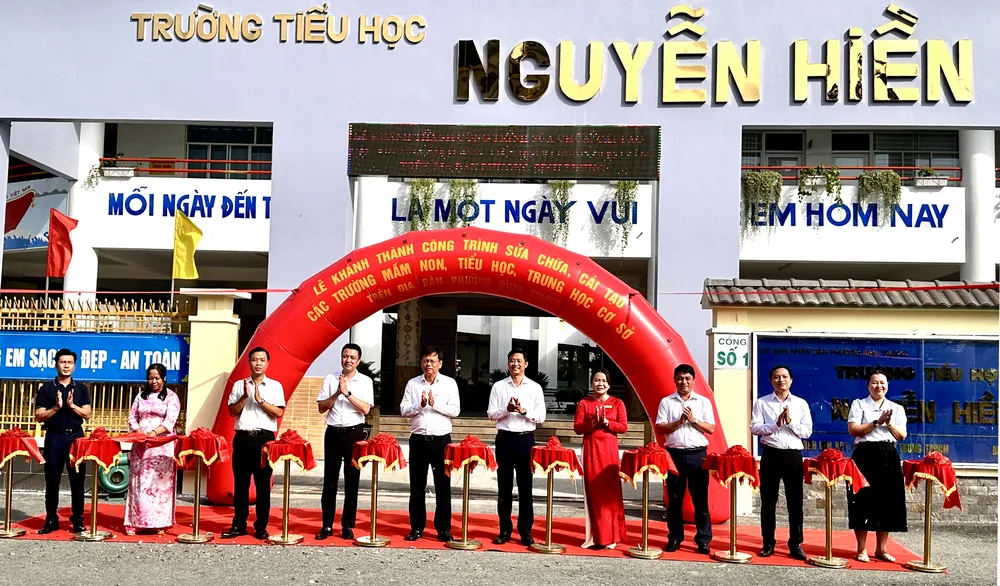 Lãnh đạo phường Bình Trưng và đại diện các trường học thực hiện nghi thức cắt băng khánh thành. Ảnh: HỒ SƠN