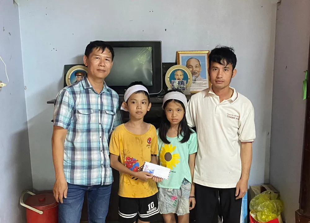 Đại diện Báo SGGP trao tiền hỗ trợ cho hai anh em Nguyễn Ngọc Khải và Nguyễn Thị Khánh Linh