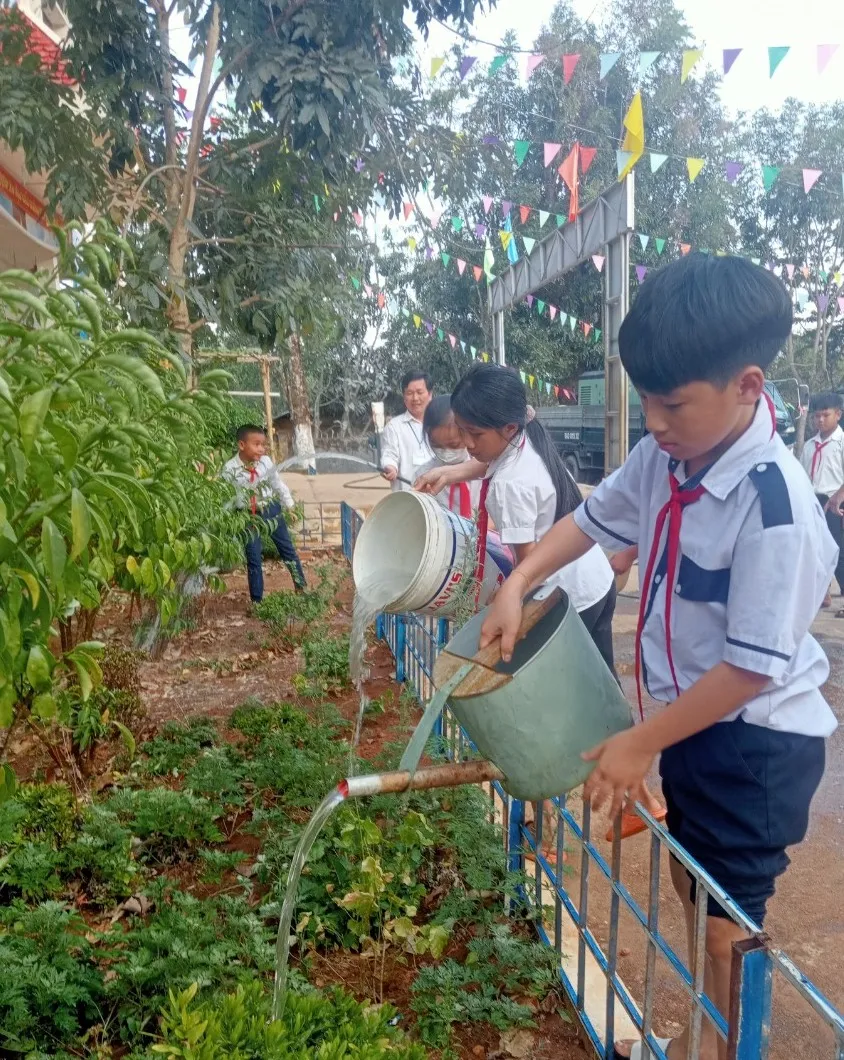 Các em học sinh dùng nước giếng khoan tưới cây
