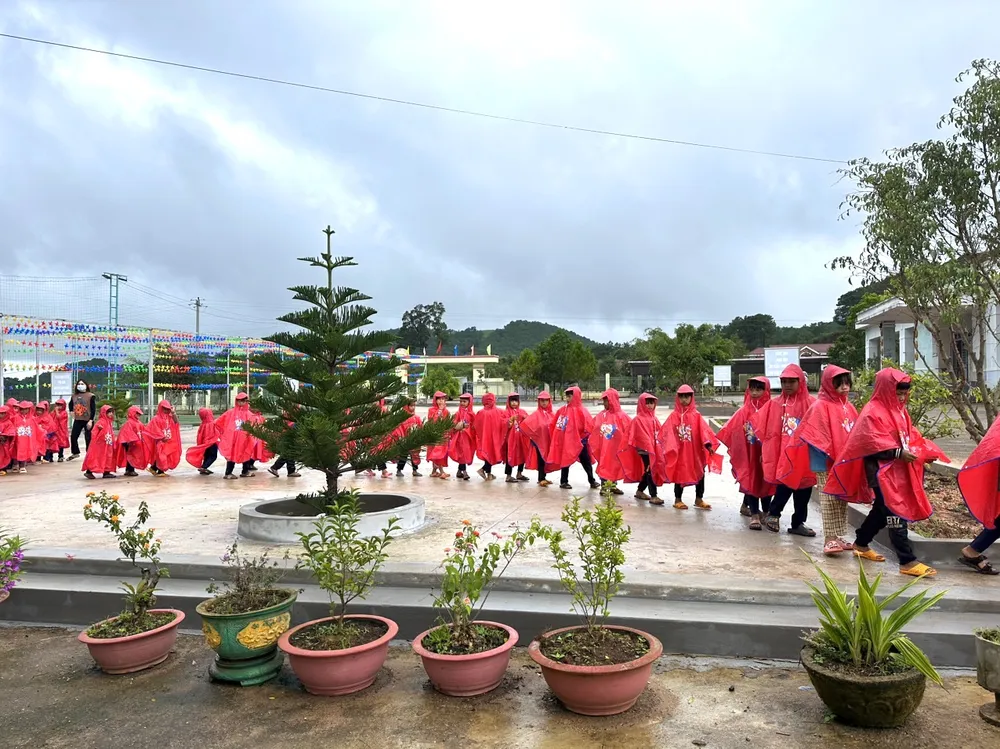 Các em học sinh nhận áo mưa